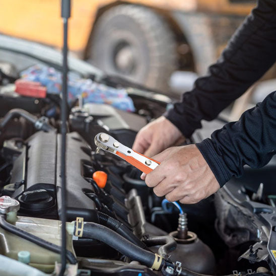 Clé plate à cliquet utilisée sur un moteur