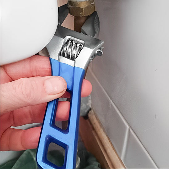 Clé à molette appliquant une force sur un écrou de plomberie