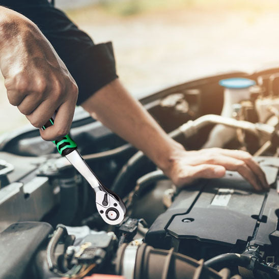 Clé à cliquet professionnelle serrant un écrou sur moteur automobile