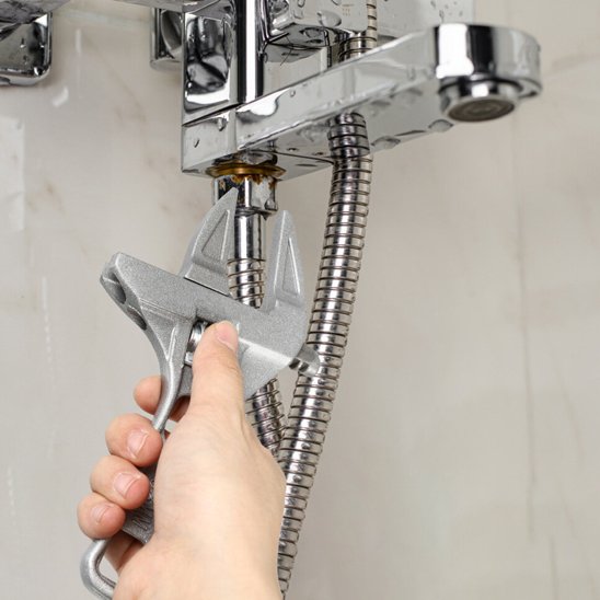 Clé à molette  en train de reparé un mitigeur