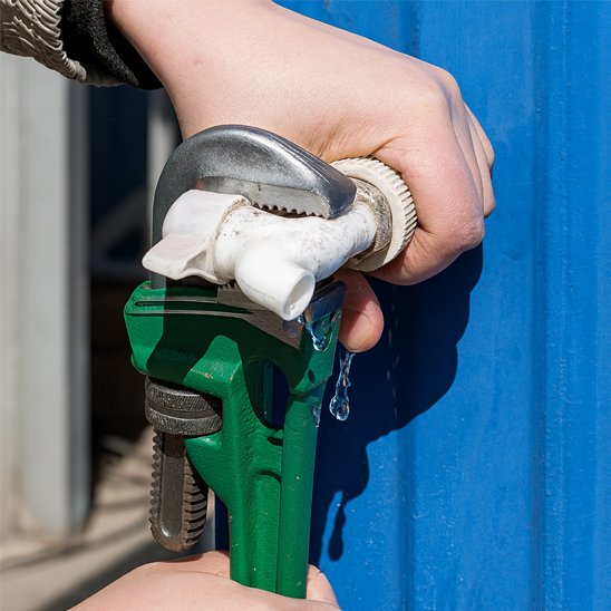 Clé  à griffe entrain de désérré un robinet en plastique 