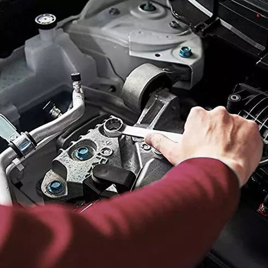 Clé plate robuste serrant un écrou sur un moteur