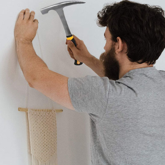 Marteau en train d_enfoncer un clou dans mur
