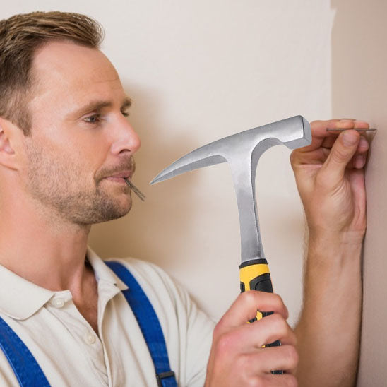 Marteau frappant un crochet pour l_accrocher au mur