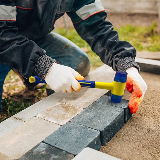 Marteaux posent avec précision des pavés au sol