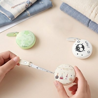 Mètre ruban rond kawaii déroulé, deux modèles colorés posés