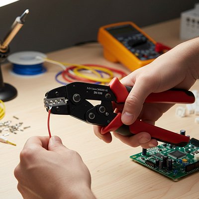 Pince à sertir entre les mains d'un bricoleur 