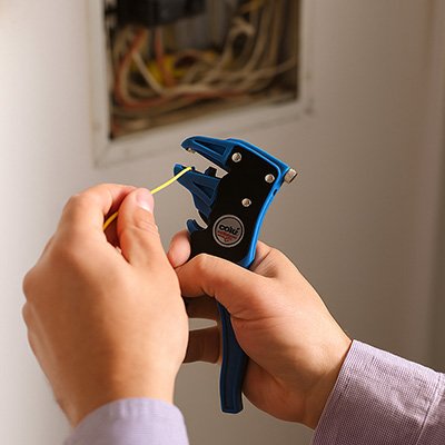 Pince a denuder ergonomique en train d’ajuster longueur du denudage