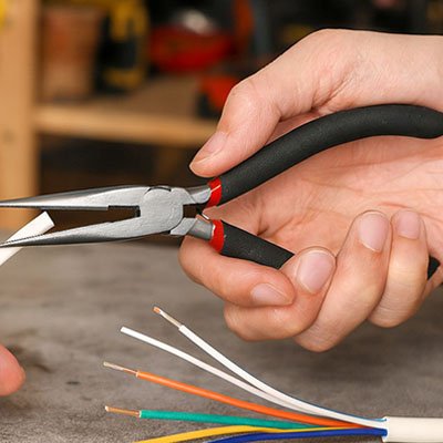 Pince a bec​ entre les mains d'un bricoleur 