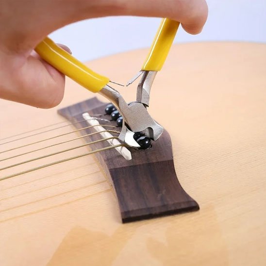 Pince coupante coupant l’excédent d’une corde de guitare
