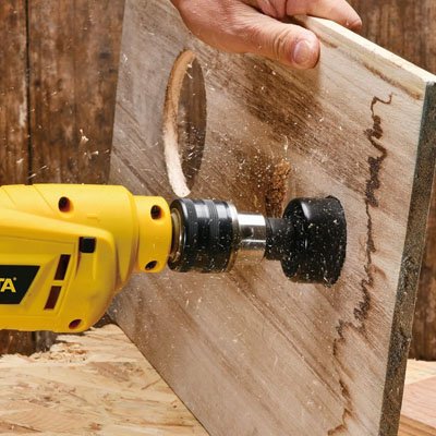 Scie cloche perçant panneau bois vertical, copeaux projetés