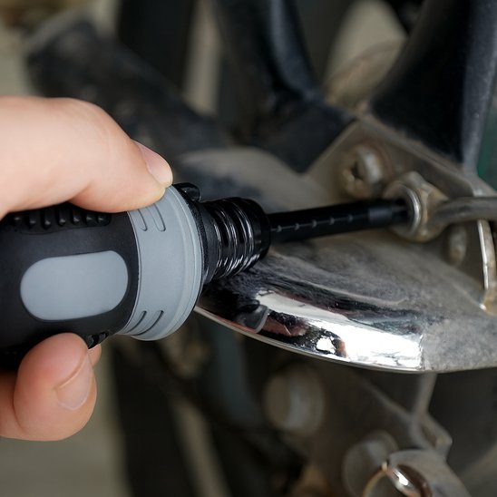 Tournevis cruciforme desserre une vis d'un moteur