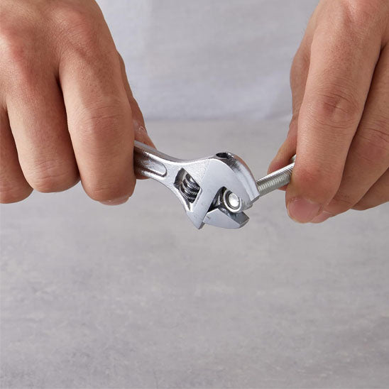 clé à molette serrant fermement un boulon métallique