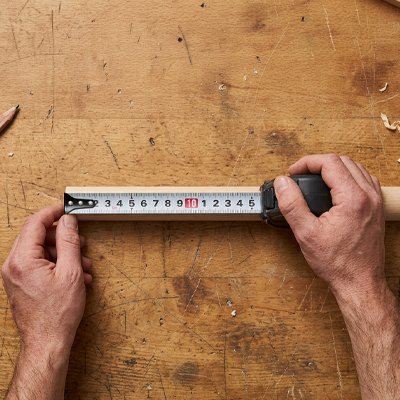 Mètre ruban tenu en main pour une mesure fiable
