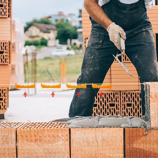 Niveau à bulle jaune alignant des rangées de briques en construction